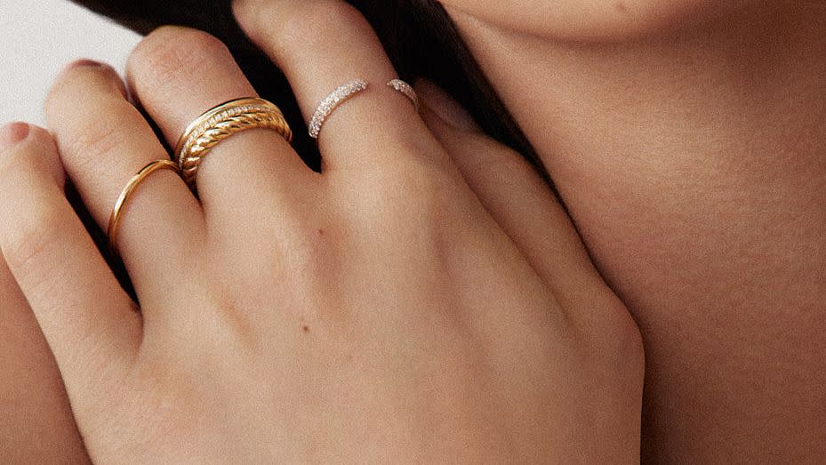 a woman's hand covered in gold jewelry