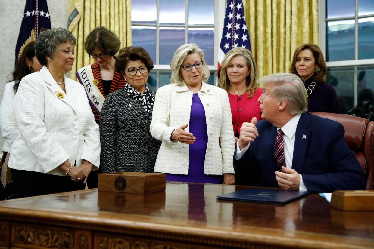 <p>Liz Cheney, dressed in white and purple, visiting Donald Trump in the Oval Office during his presidency</p> (AP)