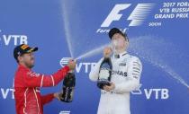 Formula One - F1 - Russian Grand Prix - Sochi, Russia - 30/04/17 - Winner and Mercedes Formula One driver Valtteri Bottas (R) of Finland and second-placed Ferrari Formula One driver Sebastian Vettel of Germany spray champagne on the podium. REUTERS/Maxim Shemetov