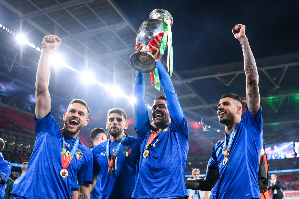 Rafael Toloi, Domenico Berardi, Leonardo Spinazzola and Emerson Palmieri celebrate with The Henri Delaunay Trophy following their team's victory induring the UEFA Euro 2020 Championship Final.