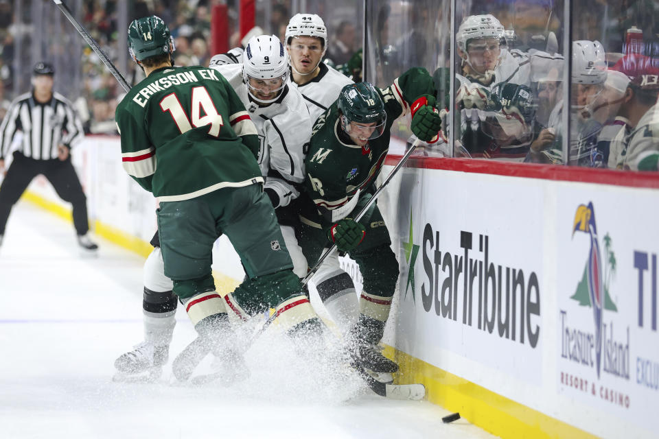 Minnesota Wild center Samuel Walker, right, and Los Angeles Kings right wing Adrian Kempe (9) battle for the puck while Wild center Joel Eriksson Ek (14) and Kings defenseman Mikey Anderson (44) look on during the first period of an NHL hockey game Thursday, Oct. 19, 2023, in St. Paul, Minn. (AP Photo/Matt Krohn)