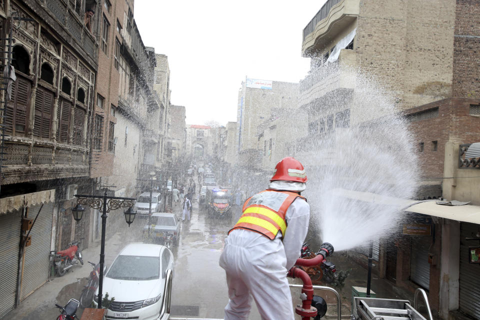A volunteer sprays disinfectant in an effort to curb the spread of coronavirus outbreak in Peshawar, Pakistan, Monday, March 23, 2020. The vast majority of people recover from the new coronavirus. According to the World Health Organization, most people recover in about two to six weeks, depending on the severity of the illness. (AP Photo/Muhammad Sajjad)