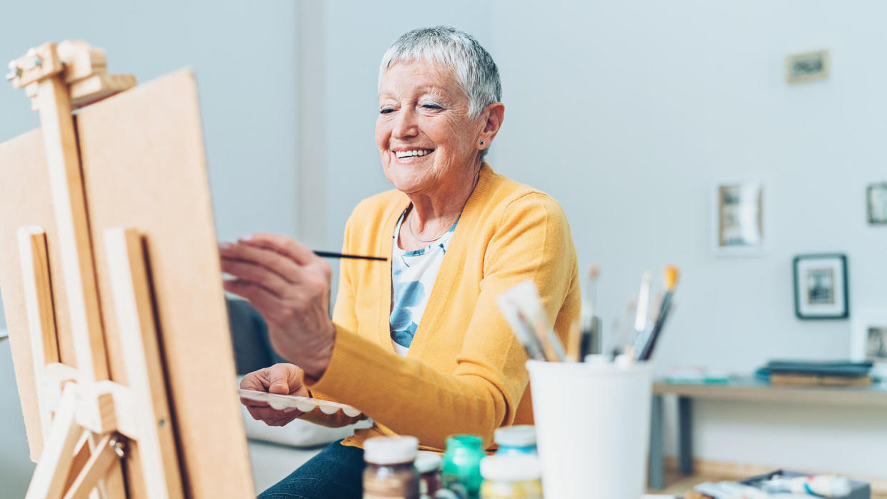 Senior artist woman drawing at home.