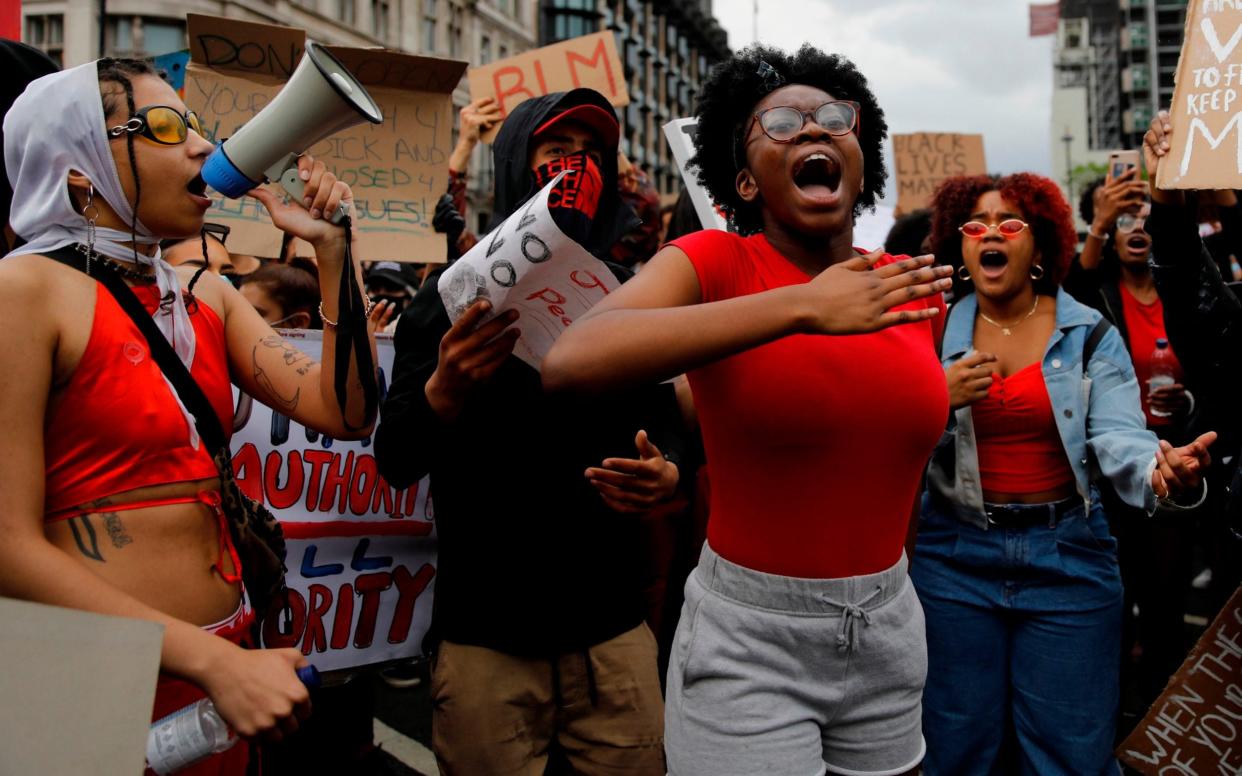 Protesters hold placards and shout slogans as they march during the anti-racism demonstration in central London following the death of George Floyd - Tolga Akmen/AFP