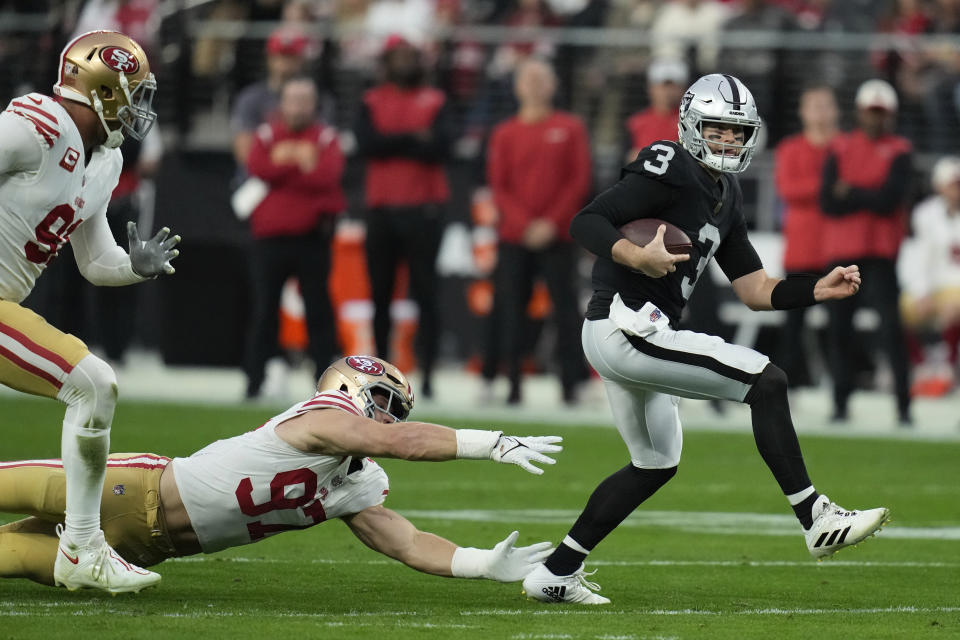 Las Vegas Raiders quarterback Jarrett Stidham (3) evades a tackle by San Francisco 49ers defensive end Nick Bosa (97) during the first half of an NFL football game between the San Francisco 49ers and Las Vegas Raiders, Sunday, Jan. 1, 2023, in Las Vegas. (AP Photo/John Locher)