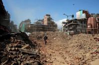 A member of Nepalese police personnel walks amidst the rubble of collapsed buildings, in the aftermath of Saturday's earthquake in Kathmandu, Nepal, April 27, 2015. REUTERS/Danish Siddiqui