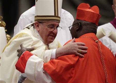 Pope Francis embraces newly elected cardinal Philippe Nakellentuba Ouedraogo of Burkina Faso during a consistory ceremony in Saint Peter's Basilica at the Vatican February 22, 2014. REUTERS/Max Rossi