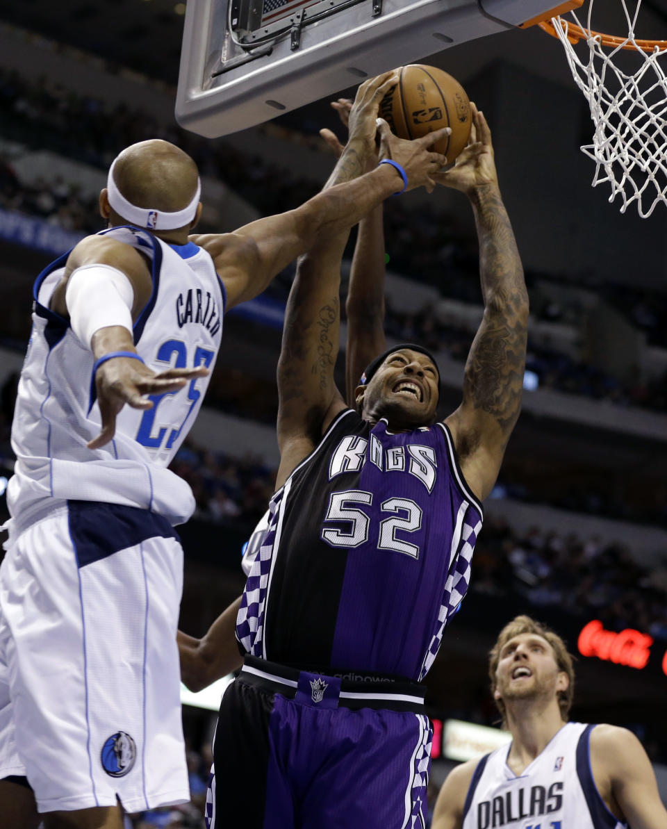 Dallas Mavericks' Vince Carter (25) tries to block Sacramento Kings' James Johnson (52) as he goes up to score in the first half of an NBA basketball game as the Mavericks' Dirk Nowitzki, bottom right, of Germany watches Wednesday, Feb. 13, 2013, in Dallas. (AP Photo/Tony Gutierrez)