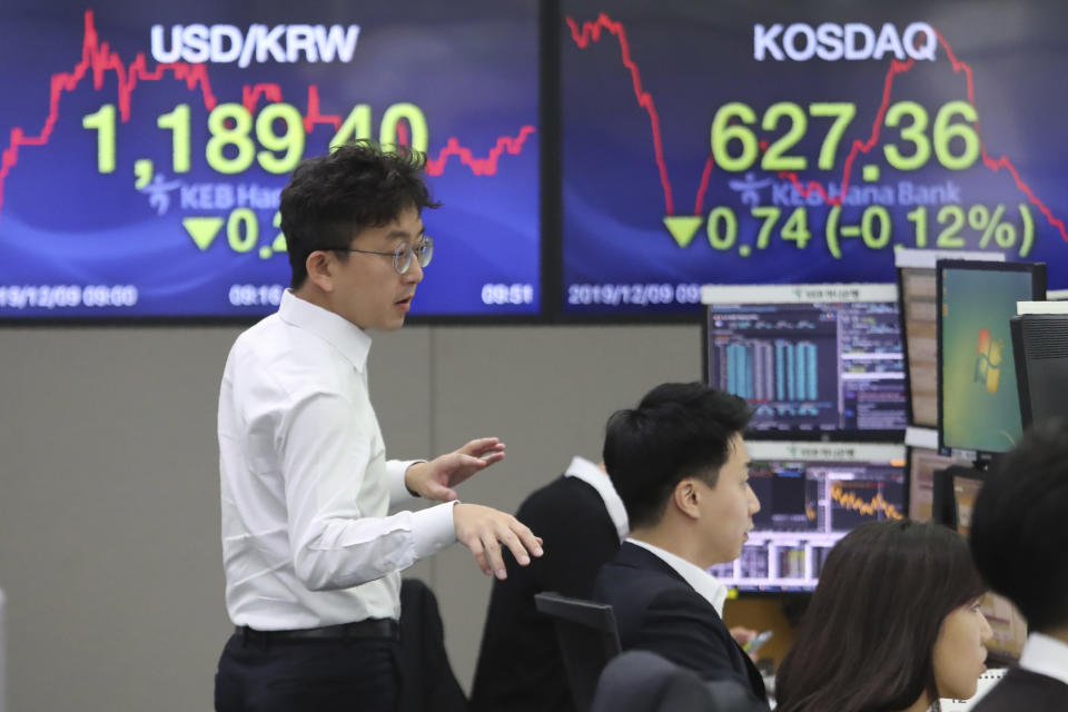 A currency trader gestures at the foreign exchange dealing room of the KEB Hana Bank headquarters in Seoul, South Korea, Monday, Dec. 9, 2019. Asian shares were mostly higher Monday cheered by a buying mood on Wall Street that came at the end of last week. (AP Photo/Ahn Young-joon)