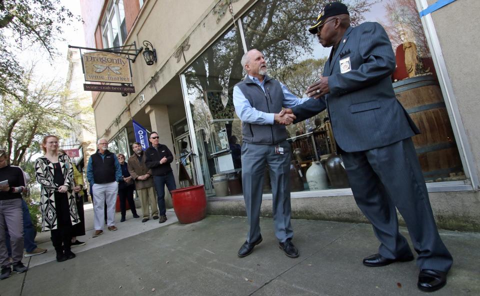 City Manager Rick Howell, left, shakes hands with City Councilman Andrew Hopper during a surprise celebration for RIck Howell held Thursday afternoon, March 16, 2023, outside the Dragonfly Wine Market in Shelby.