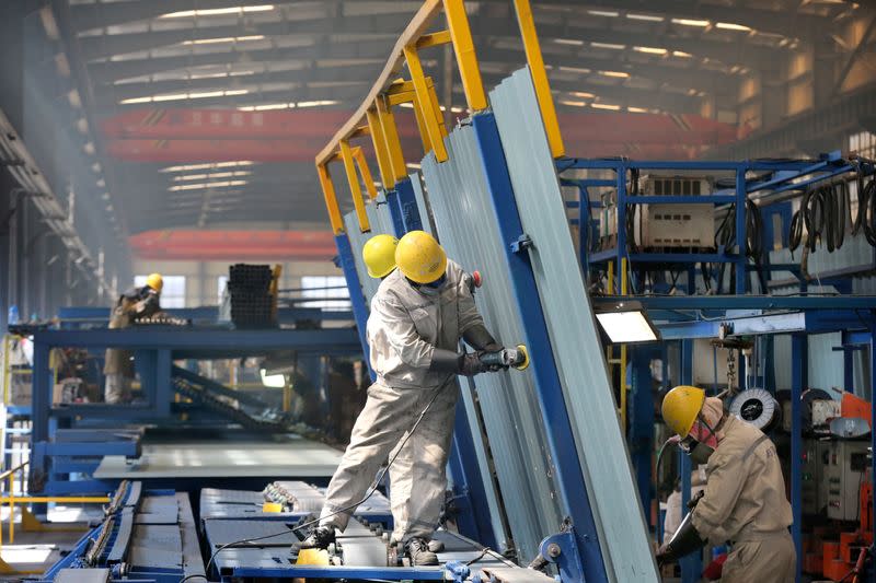 People work inside a factory of a shipbuilding industrial park at a port in Qidong city of Nantong
