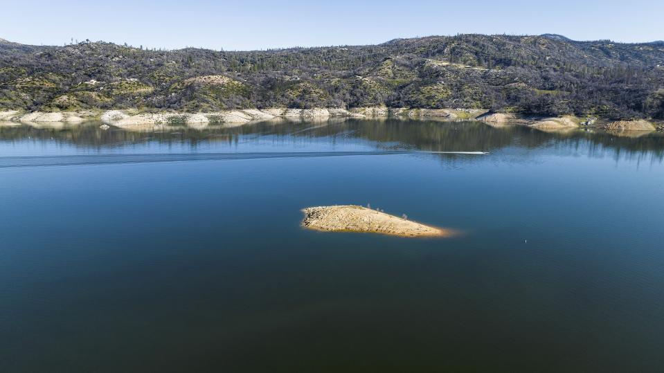 A boat crosses Lake Oroville on Sunday, March 26, 2023, in Butte County, Calif. Months of winter storms have replenished California's key reservoirs after three years of punishing drought. (AP Photo/Noah Berger)