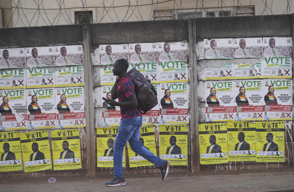 A man walks past a wall displaying portraits of Zimbabwe's President Emmerson Mnangagwa, in Harare, Sunday Aug. 20, 2023. 80-year-old Mnangagwa is now seeking re-election for a second term as president in a vote this week that could see the ruling ZANU-PF party extend a 43-year hold on power. (AP Photo/Tsvangirayi Mukwazhi)