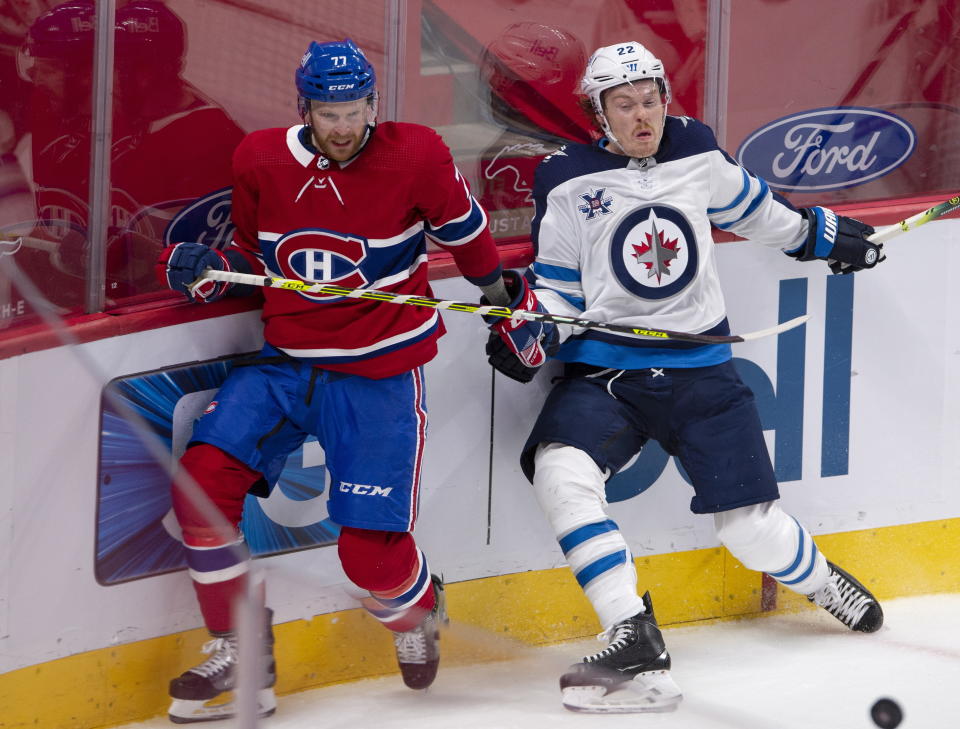 Montreal Canadiens' Brett Kulak (77) and Winnipeg Jets' Mason Appleton (22) go after a loose puck during the second period of an NHL hockey game, Thursday, April 8, 2021 in Montreal. (Ryan Remiorz/The Canadian Press via AP)