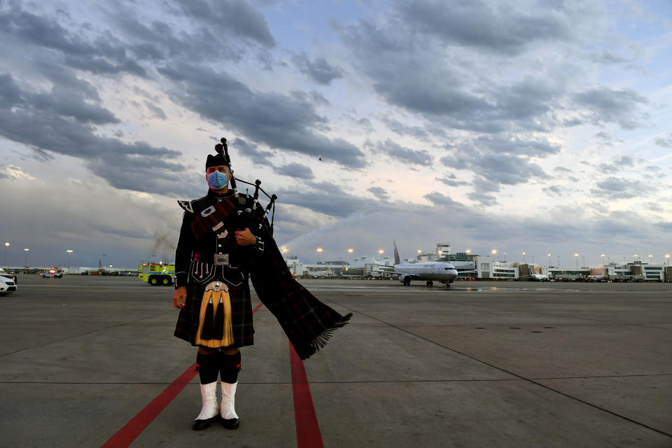 Aurora, Colo., firefighter Tom Johnson stands at attention as the United Airlines flight carrying the body of retired paramedic Paul Cary arrives at Denver International Airport on Sunday, May 3, 2020, in Denver. Cary died from coronavirus after volunteering to help combat the pandemic in New York City. (Helen H. Richardson/The Denver Post via AP, Pool)