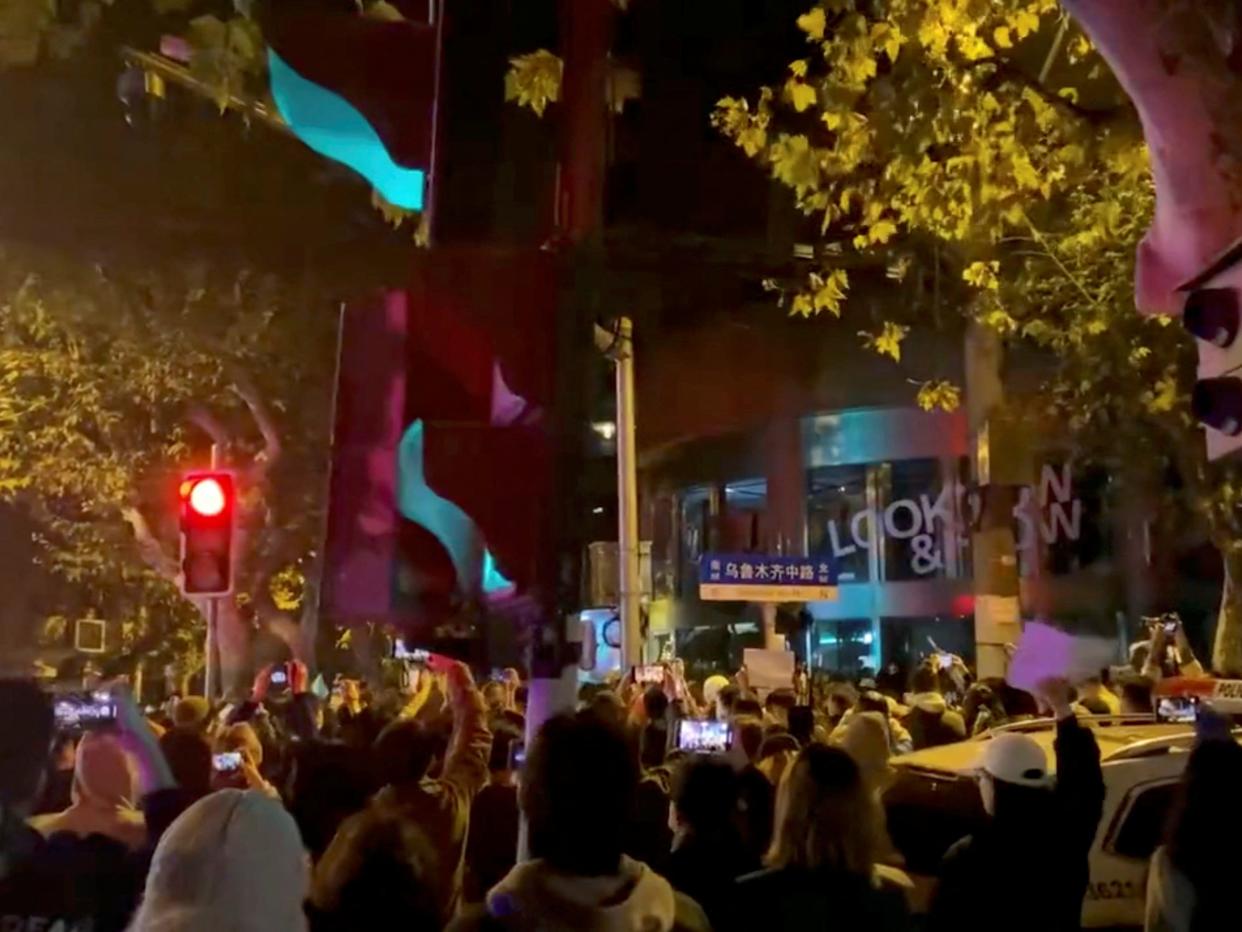 People protest against coronavirus disease (COVID-19) curbs, at the site of a candlelight vigil for victims of the Urumqi fire, in Shanghai, China, in this screengrab from a video realeased on November 27, 2022.