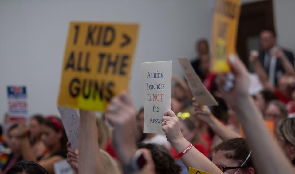 Supporters of gun safety reform hold signs during committee meetings at Cordell Hull State Office Building on Wednesday, Aug. 23, 2023, in Nashville, Tenn.