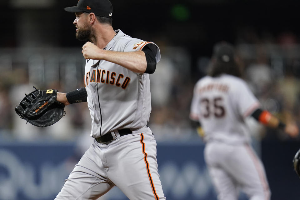 San Francisco Giants first baseman Brandon Belt, left, reacts after the Giants defeat the San Diego Padres 6-5 in a baseball game Tuesday, Sept. 21, 2021, in San Diego. (AP Photo/Gregory Bull)