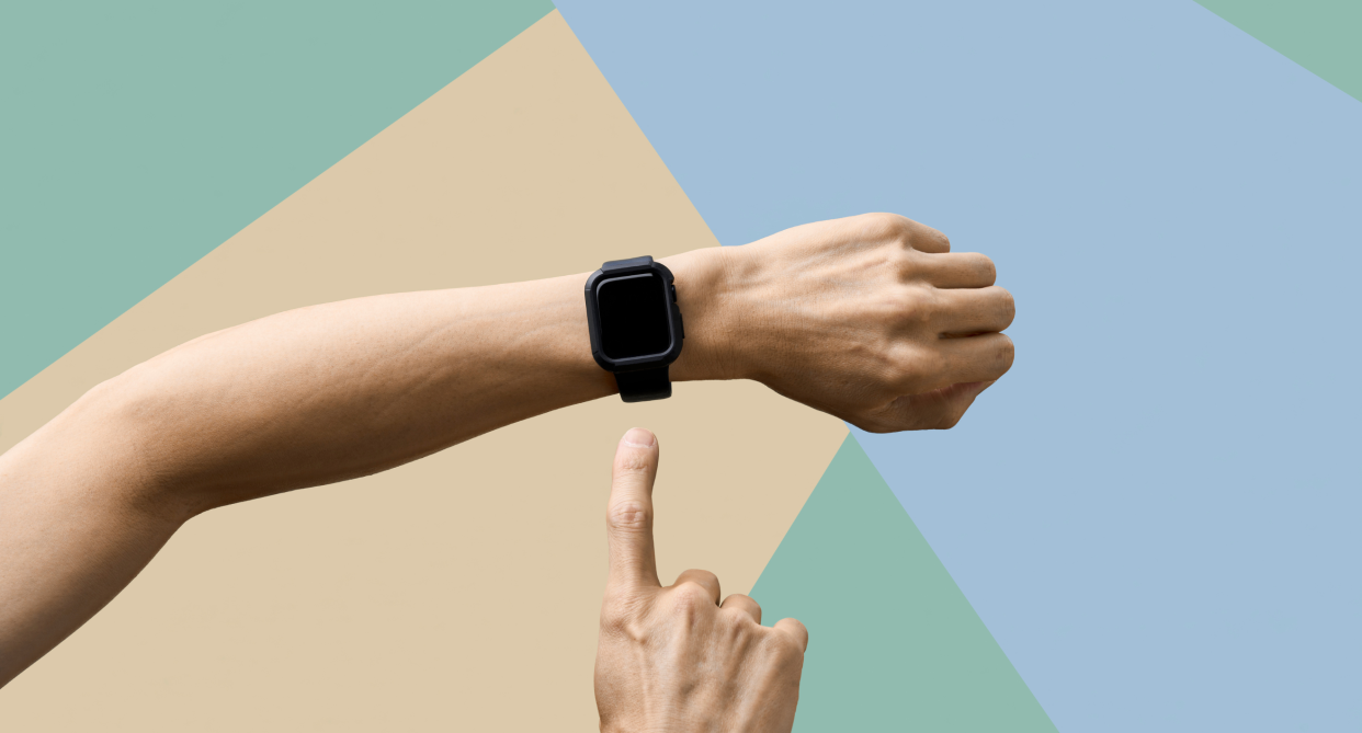 hand pointing to black smart watch on wrist, what are wearable biotrackers, Fitbit, WHOOP Band, and Oura Ring