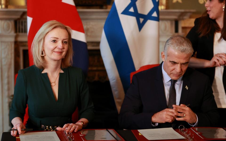 Mr Lapid and Britain's Foreign Secretary Liz Truss sign a memorandum of understanding at Britain's Foreign Commonwealth & Development Office in London on November 29