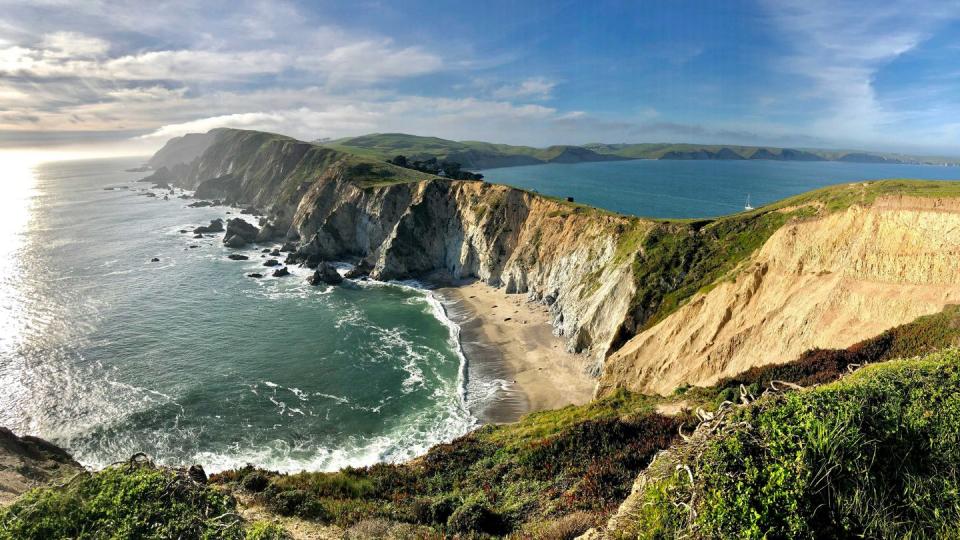 a beach with cliffs and water