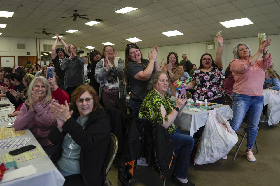 The audience gives drag queen Trixy Valentine, aka Jacob Kelley, a standing ovation for their drag story mix performance at a "Drag Bingo" fundraiser at the Nescopeck Township Volunteer Fire Company Social Hall, in Nescopeck, Pa., Saturday, March 18, 2023, to raise money for a new roof for the Berwick Theater and Center for Community Arts, in Berwick, Pa. (AP Photo/Carolyn Kaster)