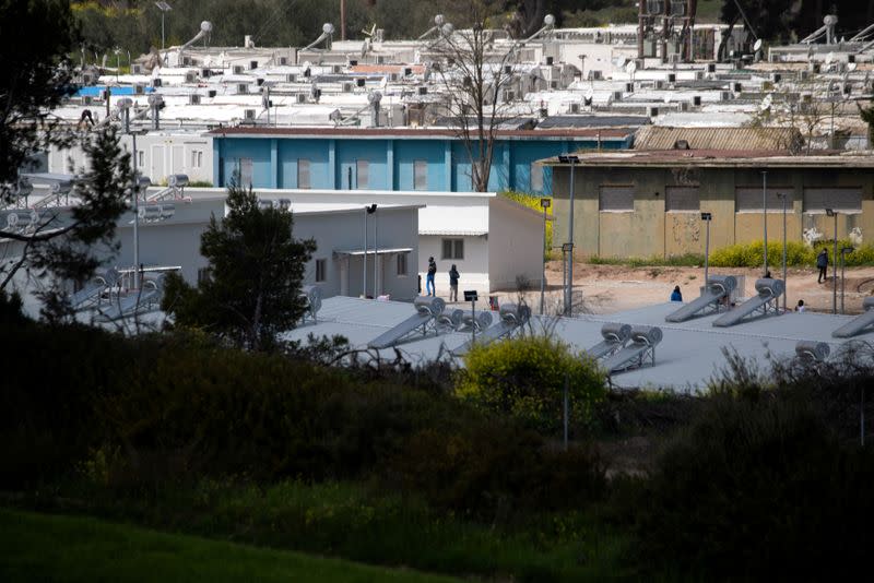 Migrants make their way in the Ritsona migrant camp after authorities found 20 coronavirus cases and placed the camp under quarantine, following the outbreak of coronavirus disease (COVID-19), in Ritsona