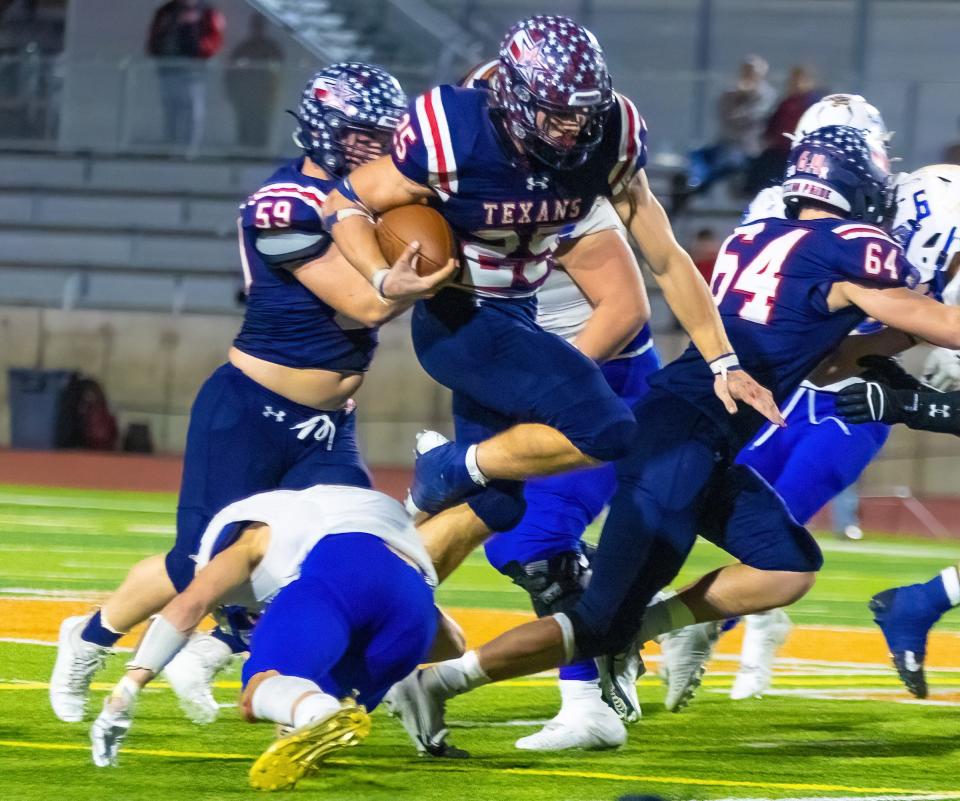 Wimberley running back Johnny Ball leaps over Lago Vista defenders while rushing for more than 300 yards in a playoff win two weeks ago. With a strong surge in the playoffs, he has helped carry the Texans into Friday's Class 4A Division II title game against Carthage.