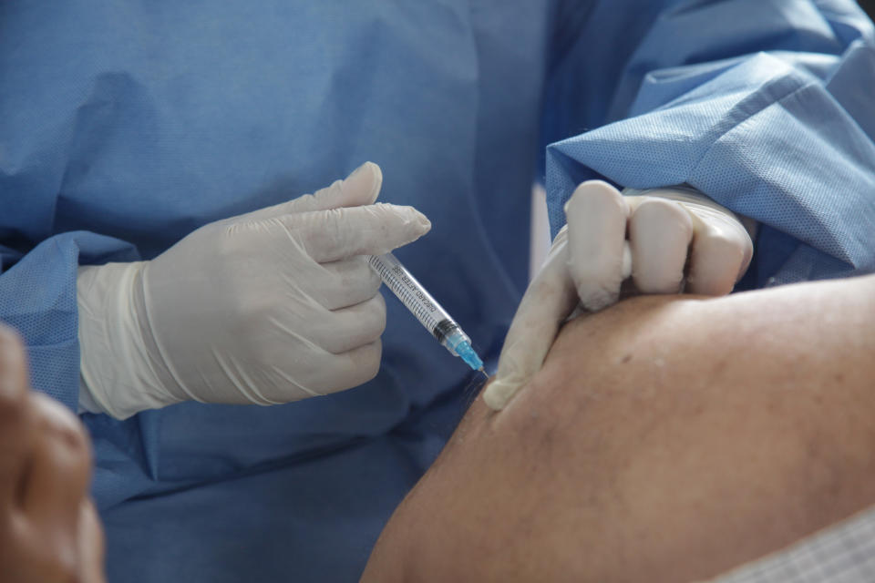 A health worker administers a dose of COVID-9 vaccine on Thursday as part of the vaccination campaign in Cuenca, Ecuador.