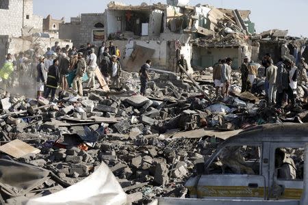 Civil defence workers and people search for survivors under the rubble of houses destroyed by an air strike near Sanaa Airport March 26, 2015. REUTERS/Khaled Abdullah