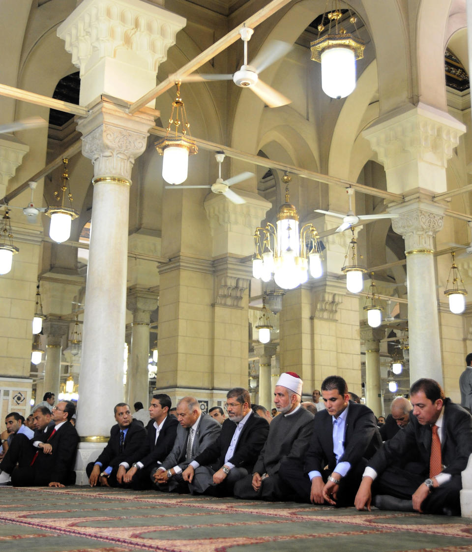 In this image released by the Egyptian Presidency, President Mohammed Morsi, center, attends Friday prayers at Sayyeda Zainab mosque in Cairo, Egypt, Friday, Sept. 7, 2012. (AP Photo/Egyptian Presidency)