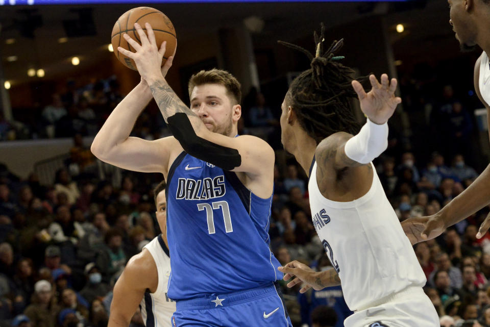 Dallas Mavericks guard Luka Doncic (77) handles the ball against Memphis Grizzlies guard Ja Morant (12) in the second half of an NBA basketball game Friday, Jan. 14, 2022, in Memphis, Tenn. (AP Photo/Brandon Dill)