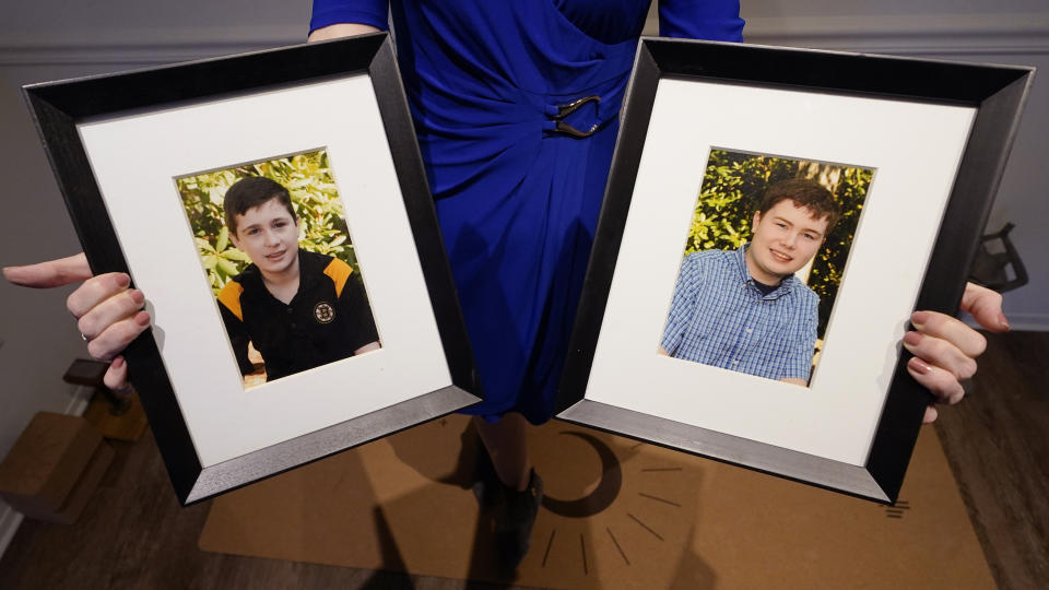 Maura Sullivan holds up photographs of her sons Neil, 19, left, and Tyler, 17, at her home, Friday, March 19, 2021, in Lexington, Mass. The memory of the coronavirus pandemic’s awful toll in nursing homes is still raw. Now, the COVID-19 relief bill is offering states a generous funding boost for home- and community-based care as an alternative to institutionalizing disabled people. “What we really want is that when our loved ones need support, we are going to be able reach out and get that support without another battle,” said Sullivan, who has two sons with autism. “We don’t want to have our kids cut out just because the potholes need to be fixed in the states.” (AP Photo/Charles Krupa)