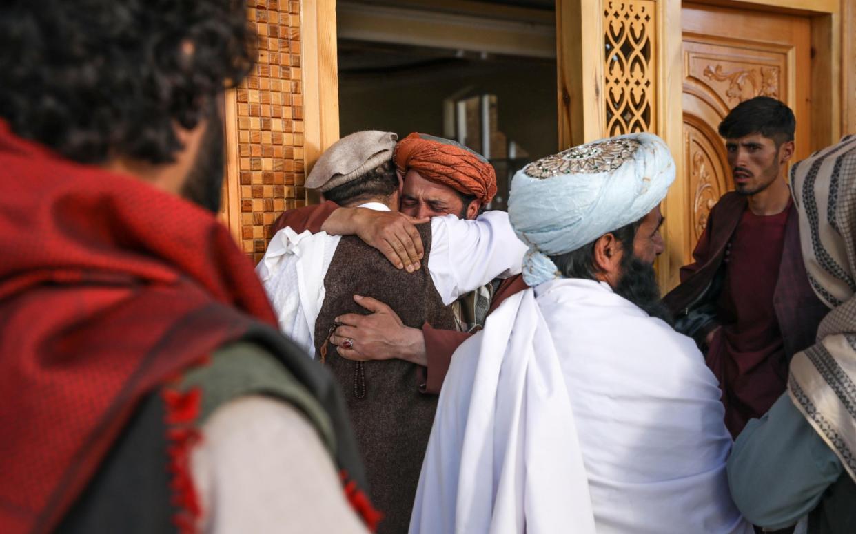 Worshippers comfort each other at the scene of an attack on a mosque in the outskirts of Kabul - HEDAYATULLAH AMID/EPA-EFE/Shutterstock 