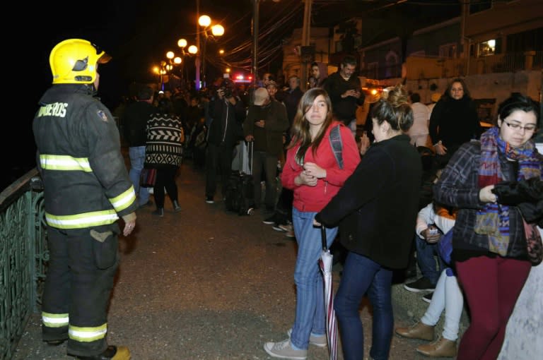 People gather in the street after a strong quake was felt in Valparaiso, northern Chile, late on September 16, 2015