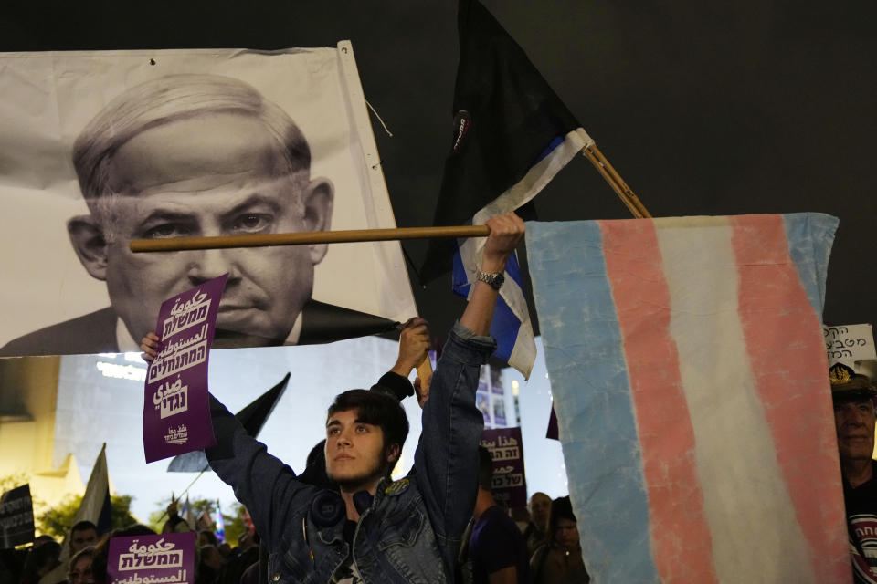 A protester holds a Transgender pride flag in Tel Aviv, Israel, to protest against Prime Minister Benjamin Netanyahu's far-right government, Saturday, Jan. 7, 2023. Thousands of Israelis protested Netanyahu's government that opponents say threaten democracy and freedoms. (AP Photo/ Tsafrir Abayov)