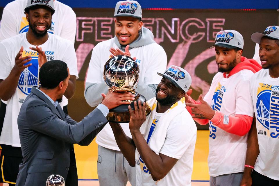 Peoria native and former Golden State Warriors player Shaun Livingston presents the western conference championship trophy to Warriors forward Draymond Green (23) on Thursday after Golden State beat the Dallas Mavericks at Chase Center for a trip to the NBA Finals.