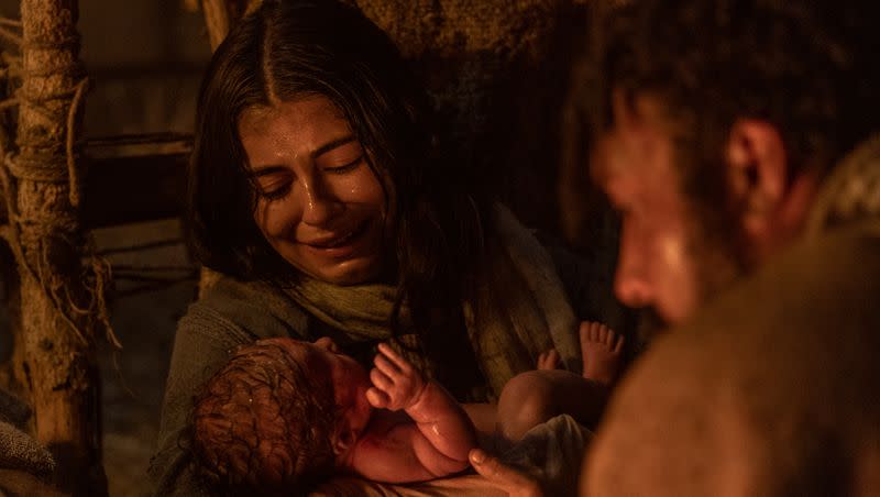 Young mother Mary, played by Sara Anne, holds baby Jesus as Joseph, played by Raja Bond watches in a scene of “Christmas With the Chosen: The Messengers.”