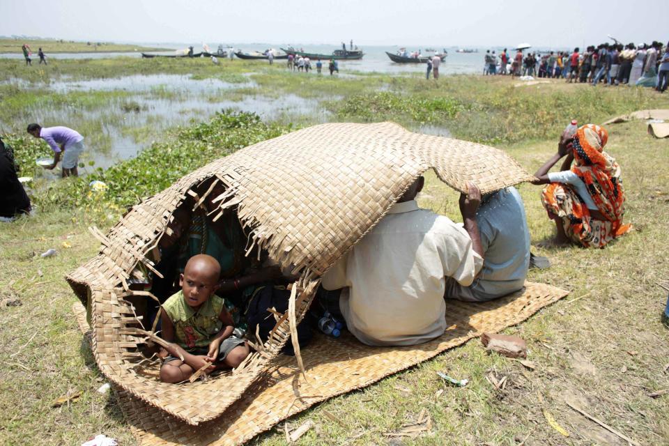 Relatives sit on the ground as they wait for news of passengers as they watch the rescue operation after the M.V. Miraj-4 ferry capsized, by the Meghna river at Rasulpur in Munshiganj district May 16, 2014. (REUTERS/Andrew Biraj)