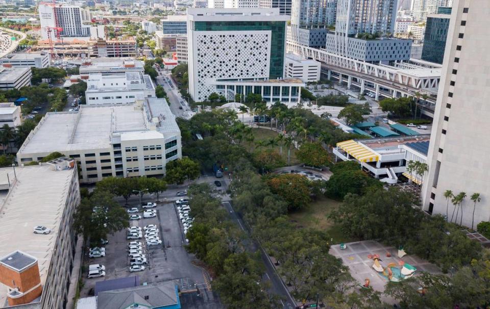 El Condado Miami-Dade ofrece los terrenos y edificios públicos que rodean a su torre del Stephen P. Clark Government Center, a la derecha, a urbanizadores como parte de un plan para crear un nuevo barrio en el downtown de la ciudad. La propiedad que se ofrece incluye la zona verde y los edificios anexos que rodean la torre, así como el estacionamiento y las instalaciones de transporte compartido del condado, abajo a la izquierda. La torre se mantendría. La escultura de Claes Oldenburg y Coosje van Bruggen "Dropped Bowl with Scattered Slices and Peels", abajo a la derecha, se trasladaría a otro lugar.