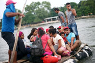 Honduran migrants, part of a caravan trying to reach the U.S., cross the Suchiate River on a raft to avoid the border checkpoint in Ciudad Hidalgo, Mexico, October 20, 2018. REUTERS/Edgard Garrido