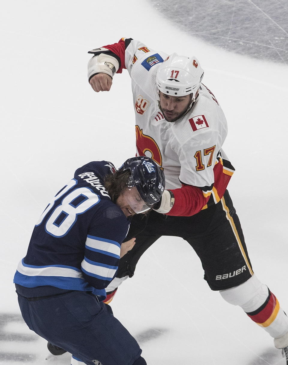 Calgary Flames' Milan Lucic (17) fights Winnipeg Jets' Nathan Beaulieu (88) during first-period NHL hockey playoff game action in Edmonton, Alberta, Thursday, Aug. 6, 2020. (Jason Franson/The Canadian Press via AP)