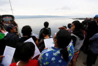 Villagers and relatives of missing passengers from a ferry accident at Lake Toba hold a prayer session at the pier of Tigaras port in Simalungun, North Sumatra, Indonesia, June 21, 2018. REUTERS/Beawiharta