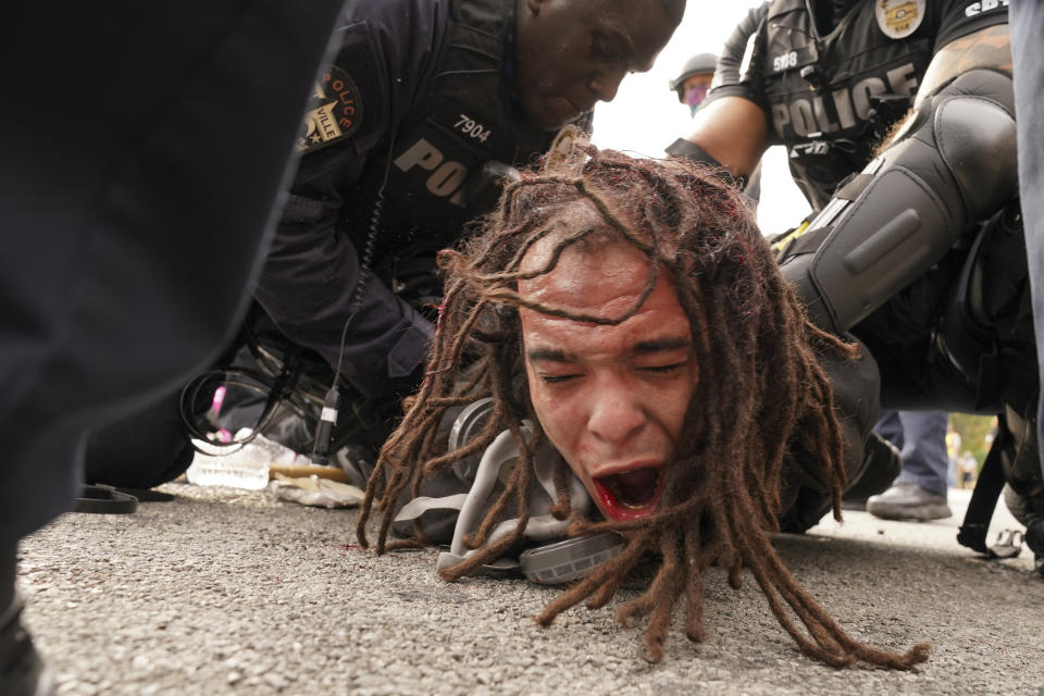 Louisville police detain a man after a group marched, Wednesday, Sept. 23, 2020, in Louisville, Ky. A grand jury has indicted one officer on criminal charges six months after Breonna Taylor was fatally shot by police in Kentucky. The jury presented its decision against fired officer Brett Hankison Wednesday to a judge in Louisville, where the shooting took place. (AP Photo/John Minchillo)