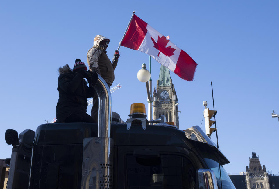 Protesters stand on the top of a truck parked in front of the Parliament buildings during a demonstration against COVID-19 restrictions, in Ottawa, Ontario, Saturday, Feb. 5, 2022. (Adrian Wyld/The Canadian Press via AP)