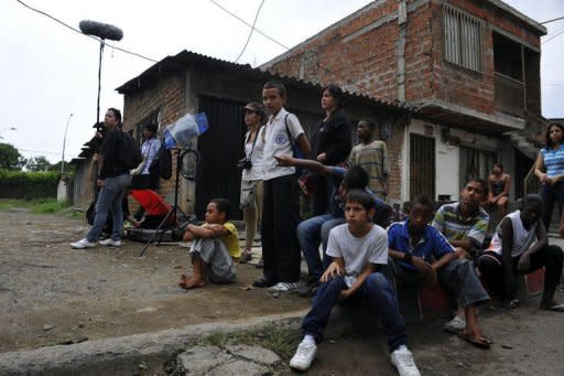 Residents look at the shooting of the movie "Petecuy" directed by Colombian Oscar Hincapie (out of picture) in Cali, department of Valle del Cauca, Colombia on June 3. In Petecuy, one of the roughest neighborhoods in Cali, one of Colombia's most dangerous cities, life and art are intertwined