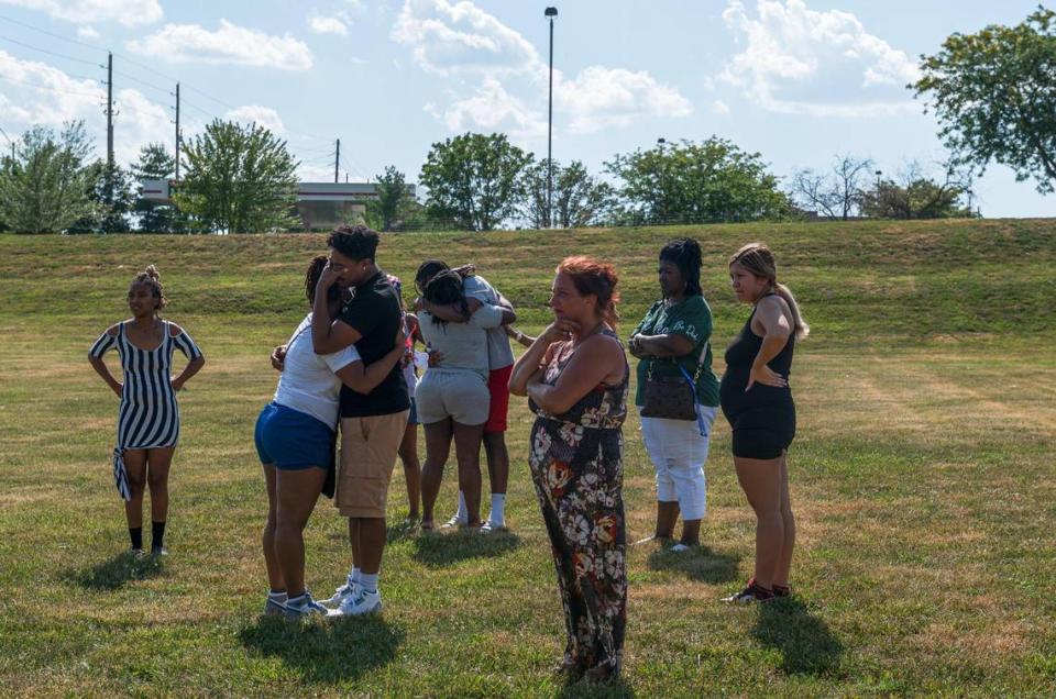 Jon Michael Rone Jr’s family embrace each other in a field near Liquor Land on Tuesday, July 4, 2023, in Kansas City. Rone was the victim of a fatal stabbing that occurred inside of Liquor Land on the 14300 block of E US 40 Highway.