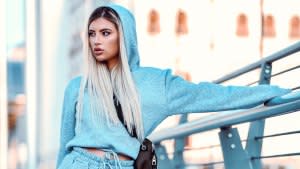 Beautiful Female In Tracksuit Walking On Bridge And Holding Railing