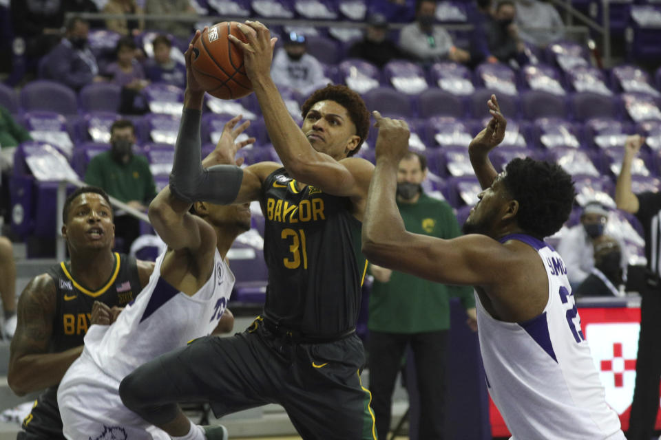 Baylor guard MaCio Teague (31) tries to go up for a shot between TCU forward Chuck O'Bannon Jr. (5) and center Kevin Samuel (21) in the second half of an NCAA college basketball game, Saturday, Jan. 9, 2021, in Fort Worth, Texas. (AP Photo/ Richard W. Rodriguez)