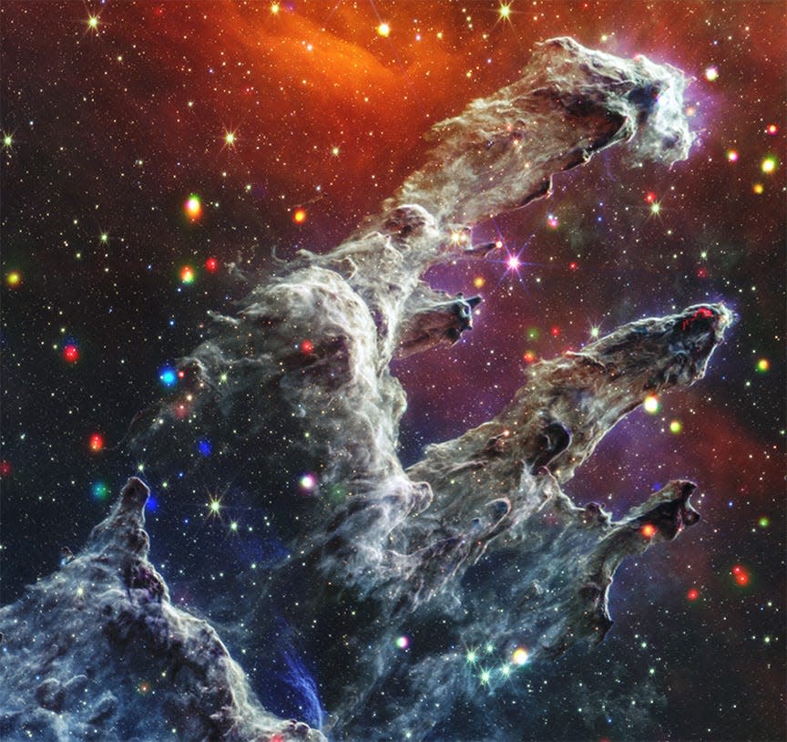 pillars of creation nebula finger shaped clouds of dust reach into dark orange and purple space with multicolored stars filling the background